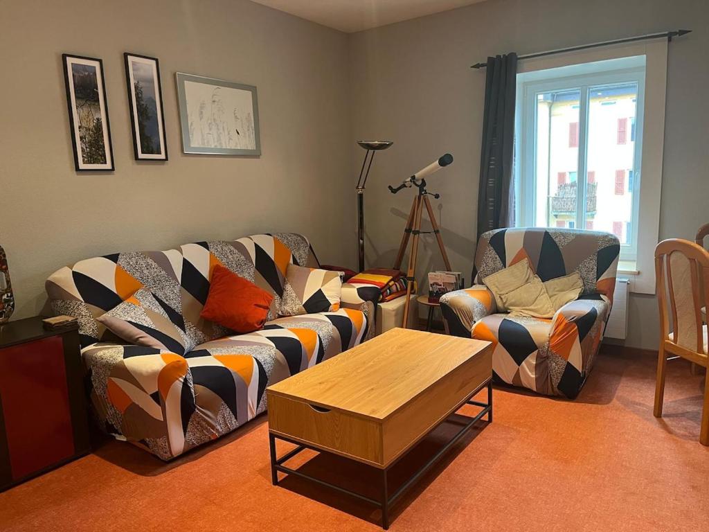 a living room with two couches and a coffee table at Charming Apartment with Jacuzzi Bathtub in La Chaux-de-Fonds