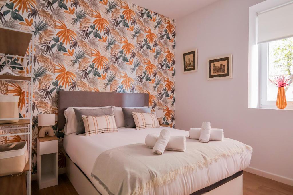 una camera da letto con un grande letto con carta da parati floreale di MELE flat a Valencia