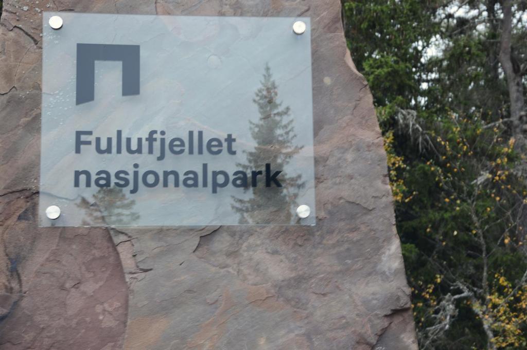 a sign for a park on a rock wall at 14 - Fulufjellets national parks-This is the place where Norway and Sweden meet in a large protected area for animals and nature in Trysil