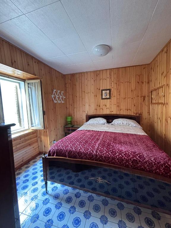 a bedroom with a large bed in a room with wooden walls at Dai Nonni Vacation Home in Acciano
