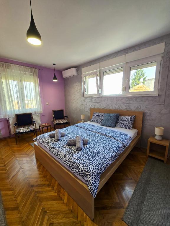 a bedroom with a bed with two stuffed animals on it at Apartman Gloria Sajam - Senjačka pijaca in Senjak (historical)