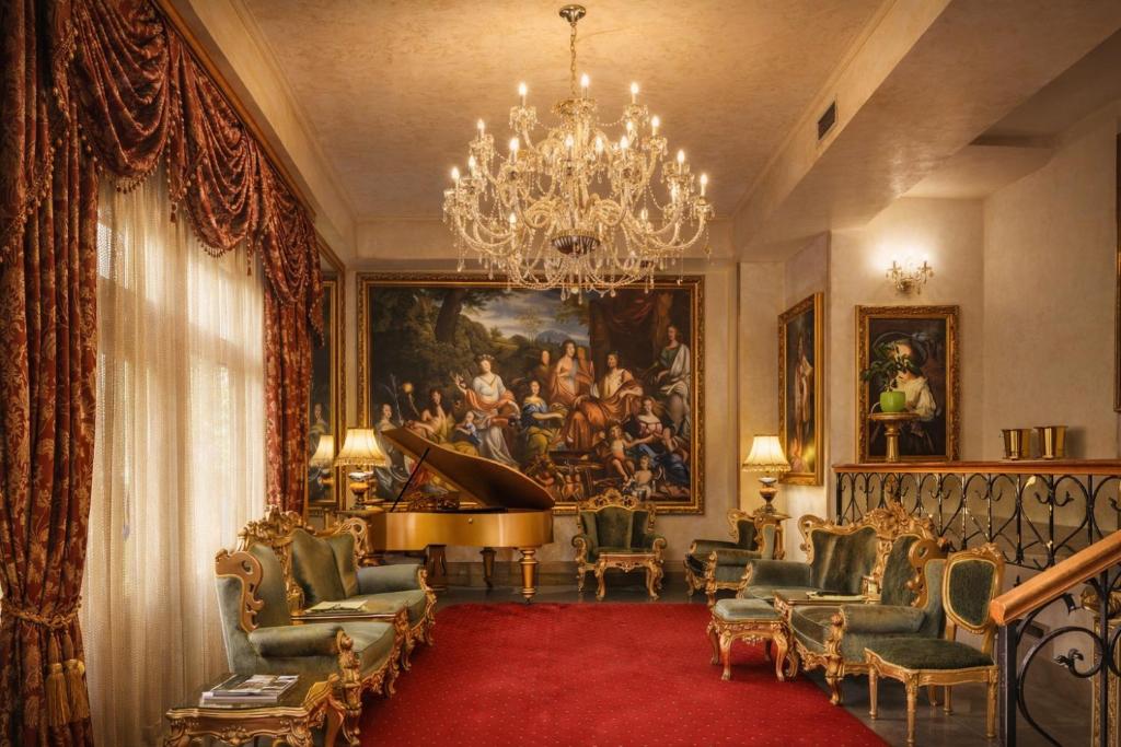 a living room with a large painting and a grand piano at Premier Prezident Garni Hotel and Spa in Sremski Karlovci