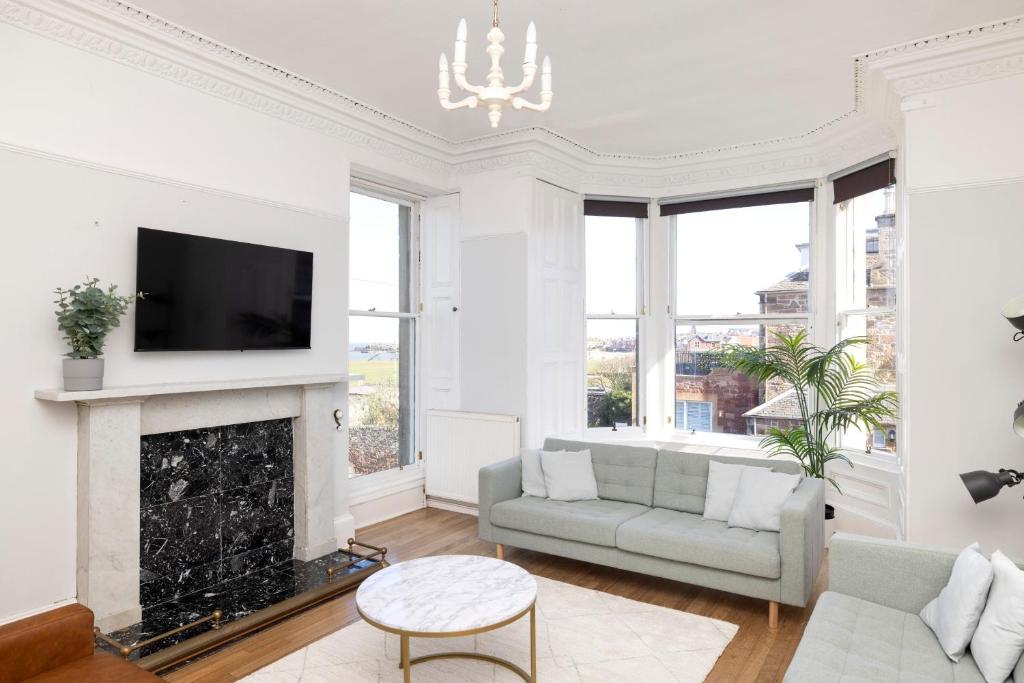 a living room with a couch and a fireplace at Detached House with Sea Views & Parking in North Berwick