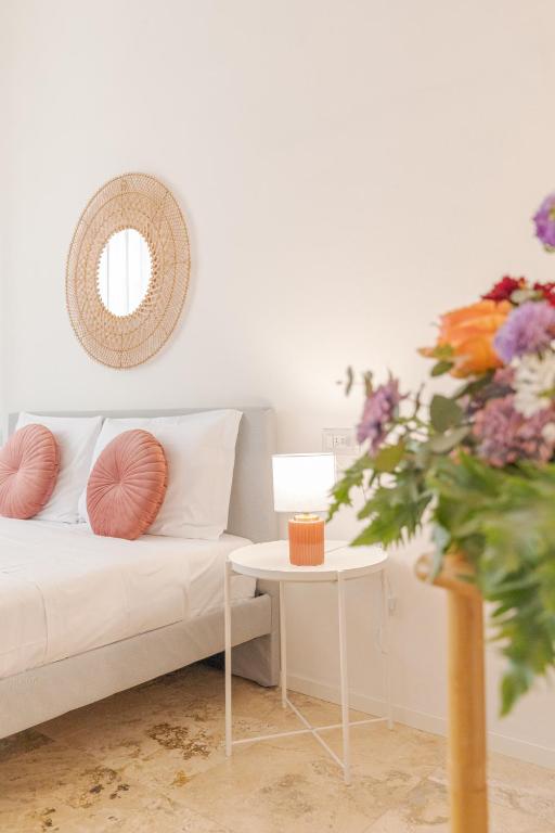 a living room with a couch and a table with a vase of flowers at L'Acqua e la Pietra in Rapolano Terme