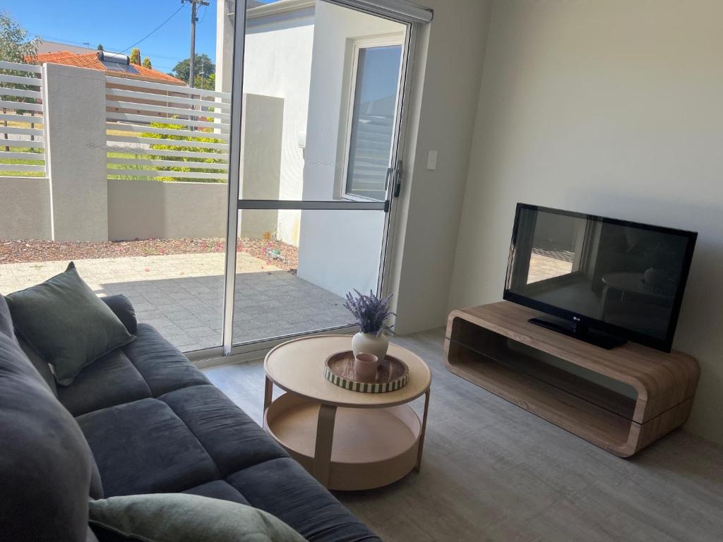 a living room with a couch and a flat screen tv at Sweet Home Property 7A Kewdale in Perth