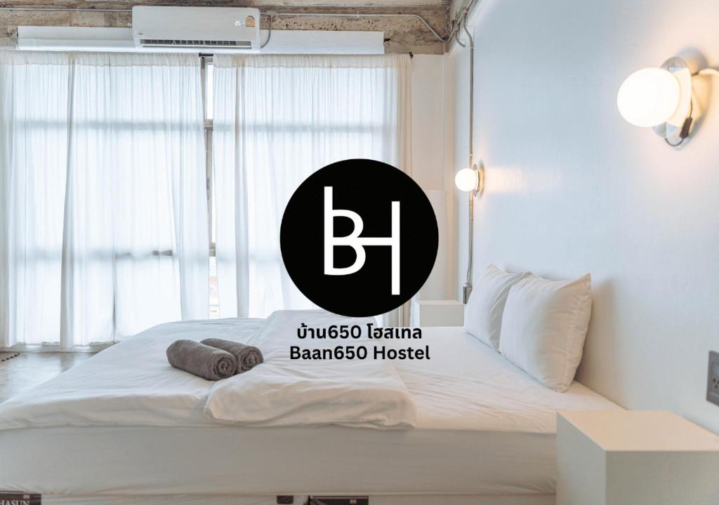 a bed with a black and white sign on it at BAAN650 Hostel in Hat Yai