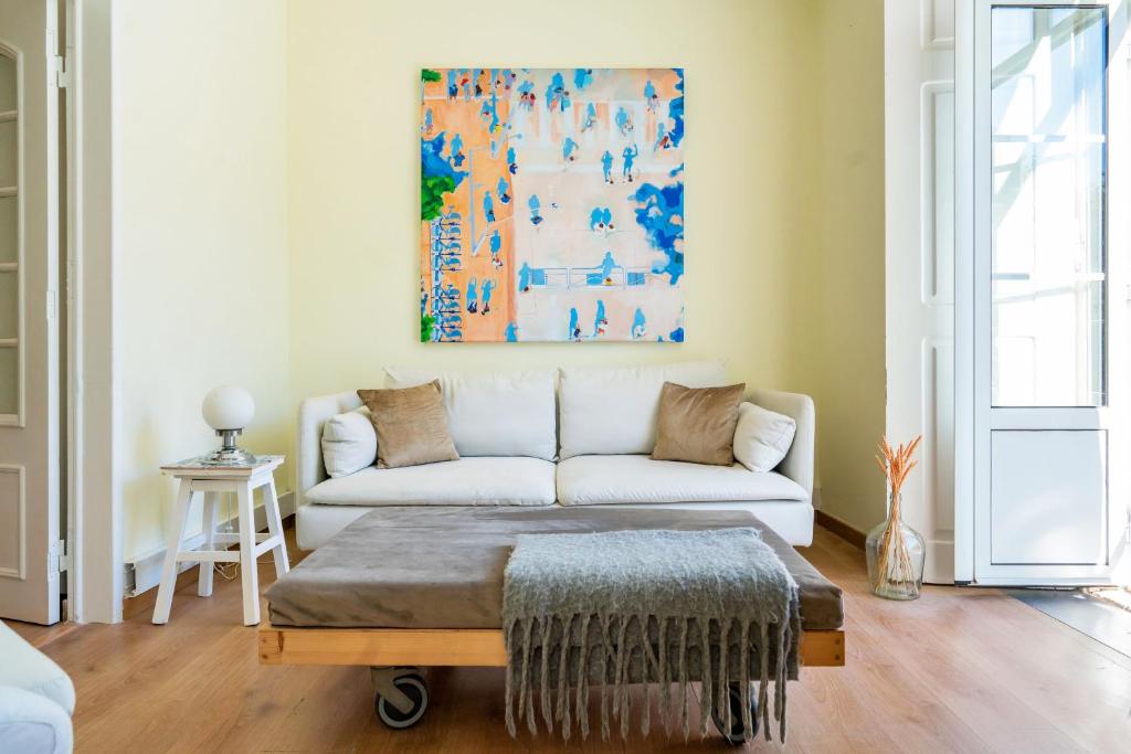 a living room with a couch and a painting on the wall at Casa Saint Yves in Setúbal