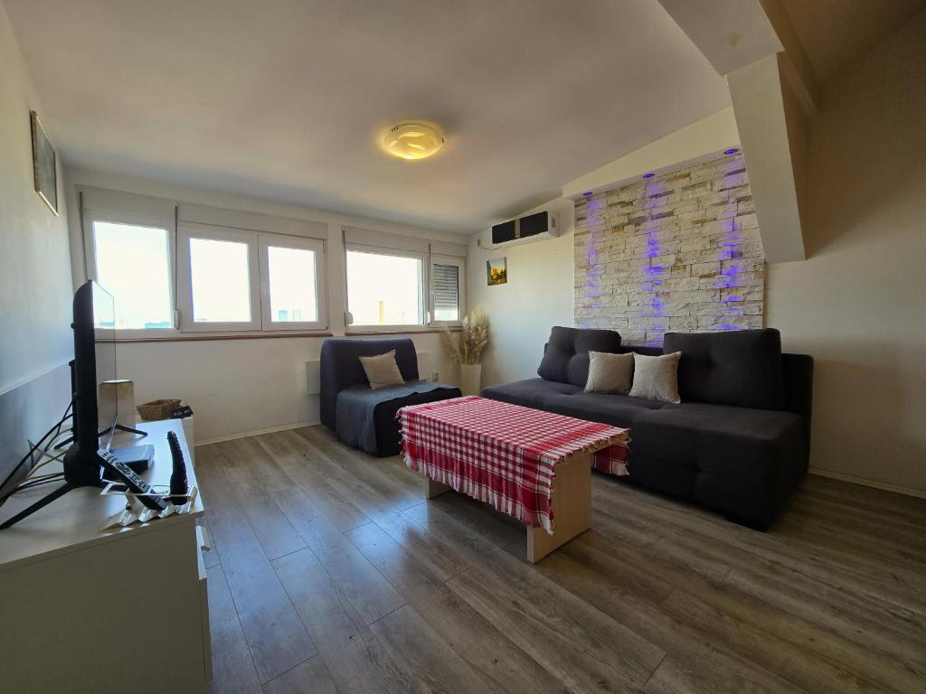 a living room with a couch and a television at Apartman Gloria Sajam - Panorama in Belgrade