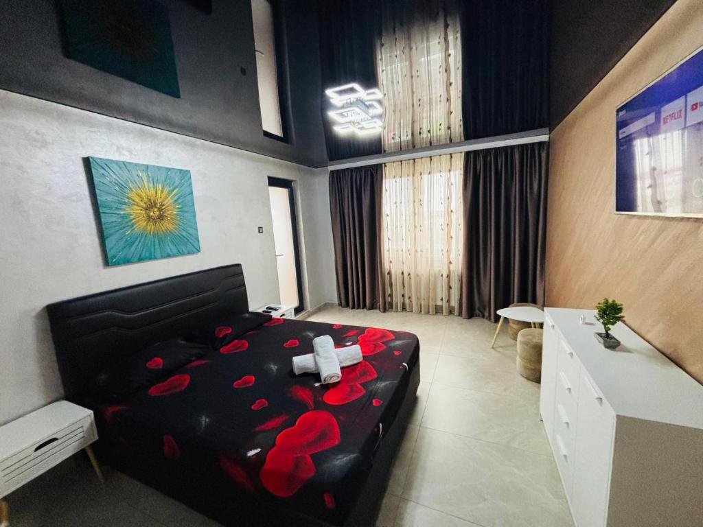 a bedroom with a black bed with red roses on it at BGD Residence in Galaţi