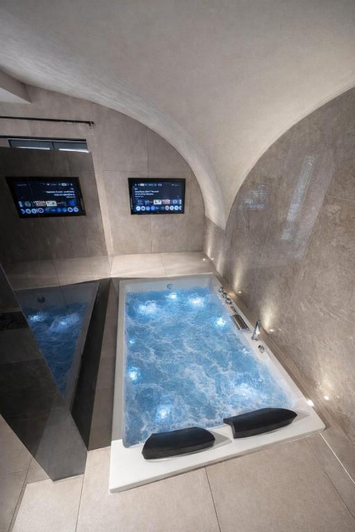 a large bath tub with two monitors in it at Twentyseven Luxury Suite in Catania