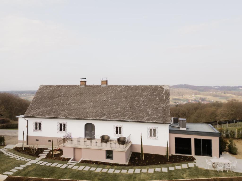 a white house with a gray roof at Exklusives Ferienhaus in Alleinlage mit privater Sauna - La petite maison in Straden