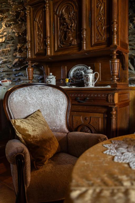 a chair with a pillow sitting next to a table at Casa do Lagar in Vale do Porco