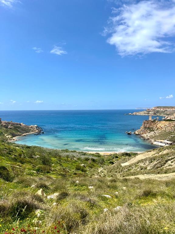 a view of the ocean from a hill at Sunset Haven Manikata - Walking distance to Golden Bay in Manikata