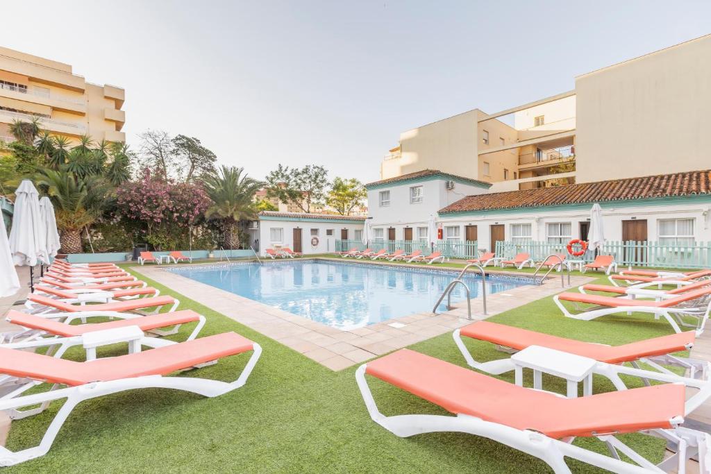 a pool with chaise lounge chairs and a swimming pool at BLUESEA Miramar Fuengirola in Fuengirola