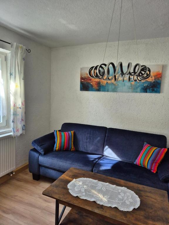 a living room with a blue couch and a table at Dahoam am Silberberg in Bodenmais