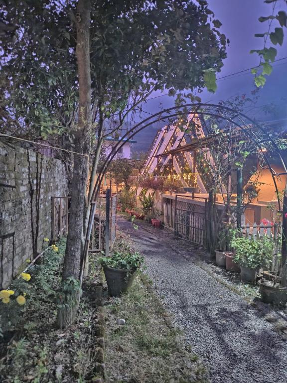 a garden with a roller coaster in the background at Cottages At Village Bhimtal-Naukuchiatal in Bhīm Tāl