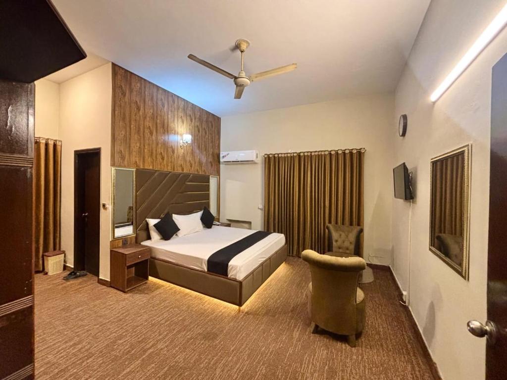 a bedroom with a bed and a ceiling fan at Green Land Hotel Lahore in Lahore