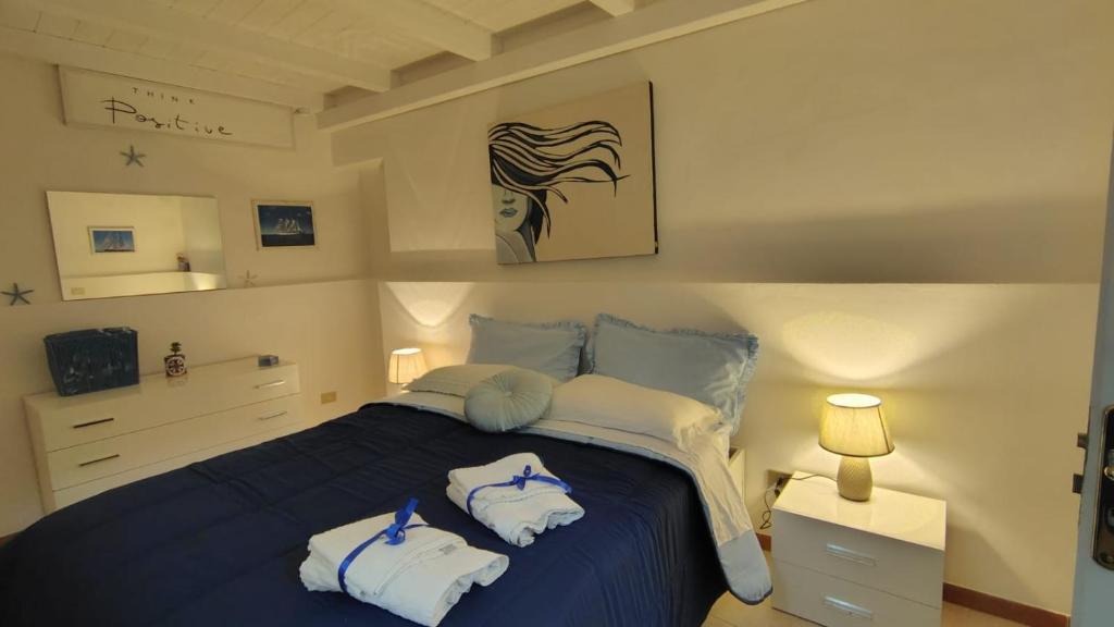 a bedroom with a blue bed with towels on it at Room34Trani in Trani