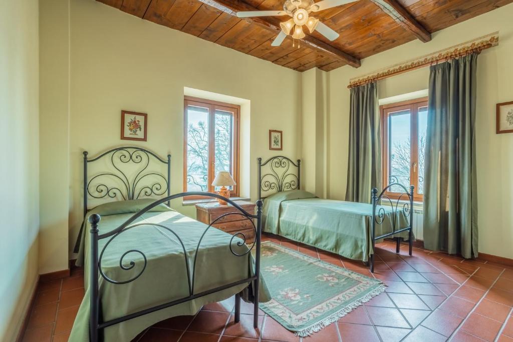 a bedroom with two beds and a ceiling fan at Agriturismo i Due Casini in Riano