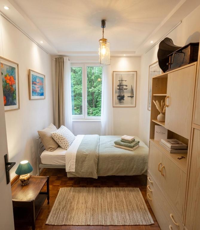 a small bedroom with a bed and a window at Art house Tufi in Bistrica ob Sotli