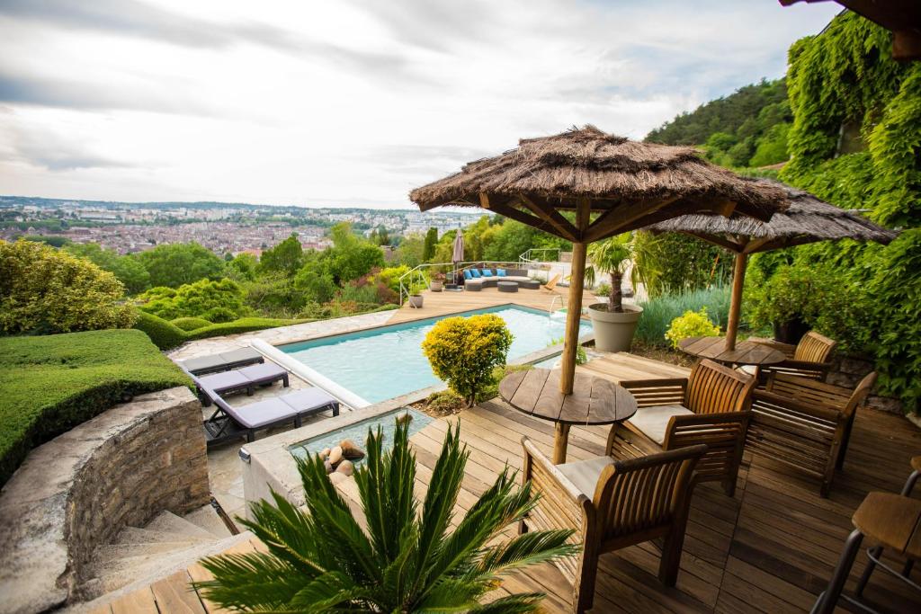 a villa with a swimming pool and an umbrella at Les Terrasses de Besançon in Besançon