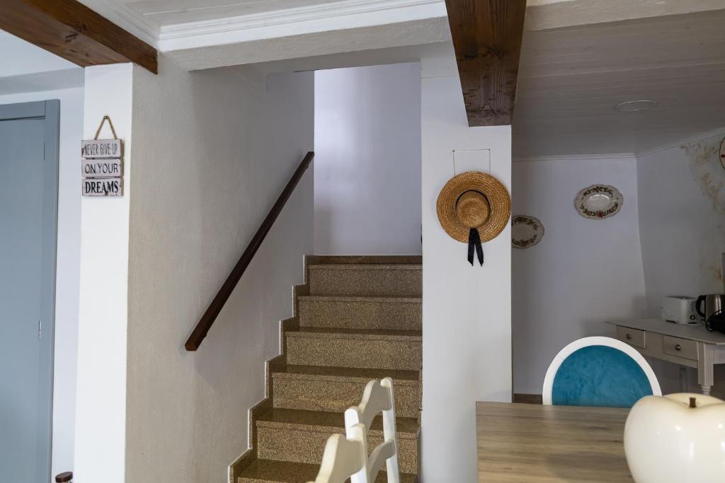 a staircase in a house with a straw hat on the wall at Casa do Balcão in Meda