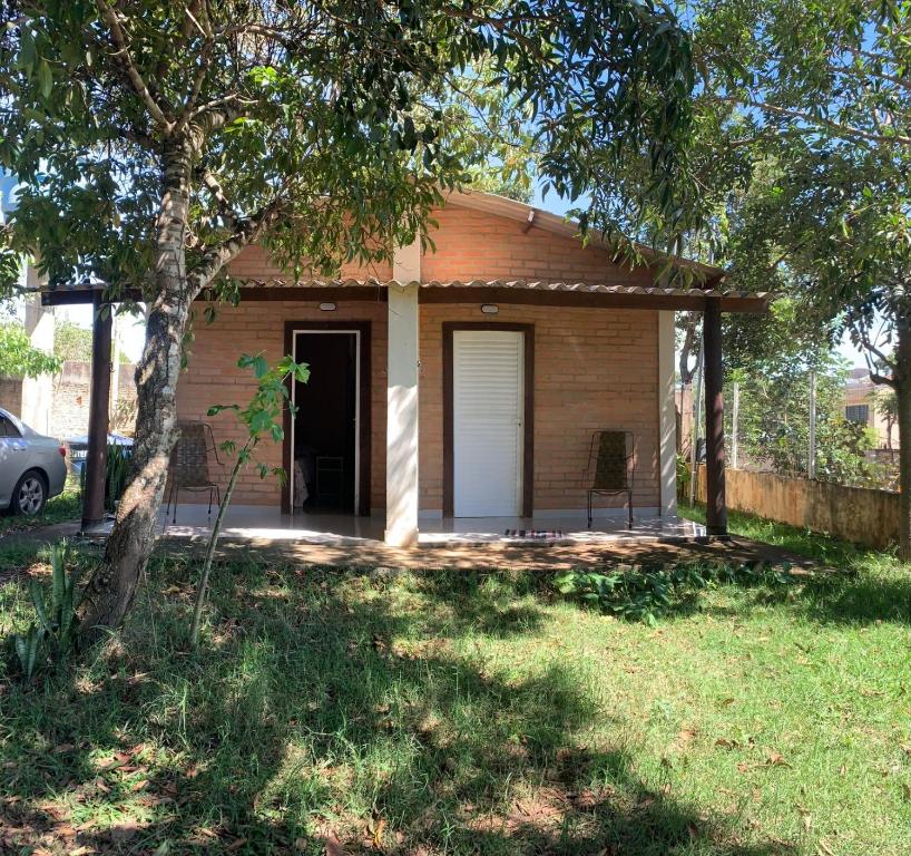 a small house with a door and a yard at Casa Stúdio Uirá - suíte in Chapada dos Guimarães