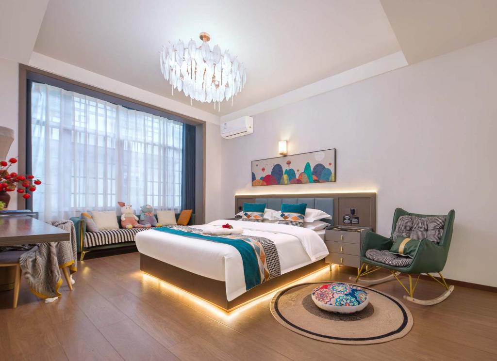 a bedroom with a large bed and a chandelier at JINGJING·YUNXI·WEITANG HOTEL in Zhangjiajie
