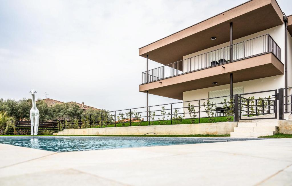 a building with a giraffe standing next to a pool at Ariom Apartments in Moniga