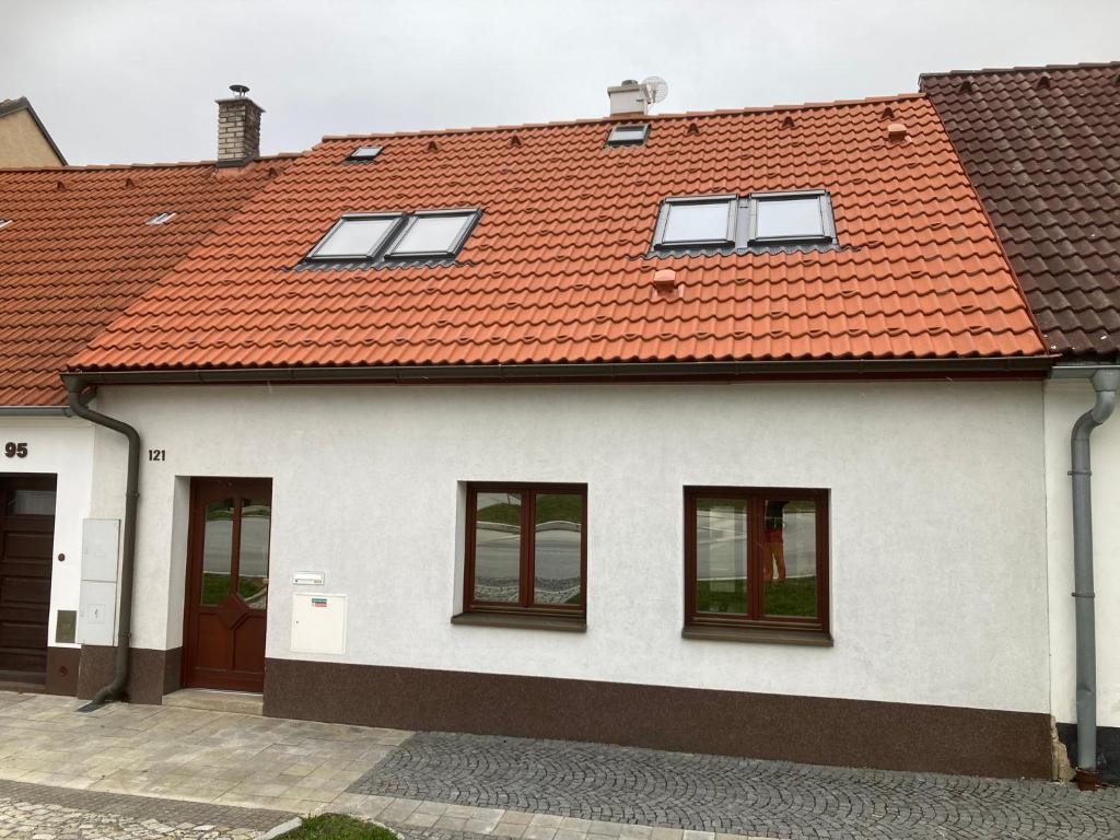 a white house with an orange roof at Ubytování pod Nadymákem in Telč