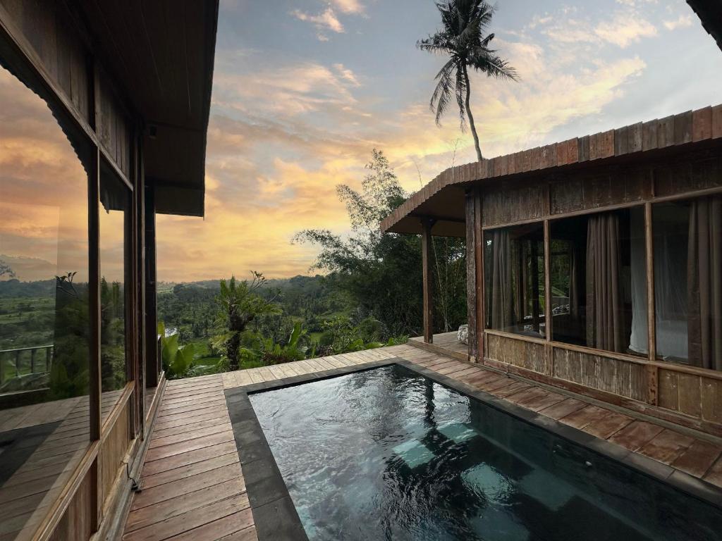 a house with a swimming pool next to a building at Panoramic Samplik View Sidemen in Silebeng