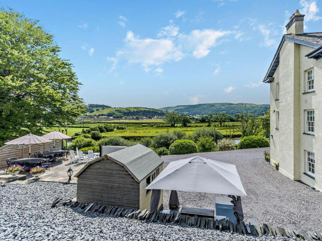 a building with an umbrella and a table and chairs at 5 Bed in Machynlleth oc-92513 in Machynlleth