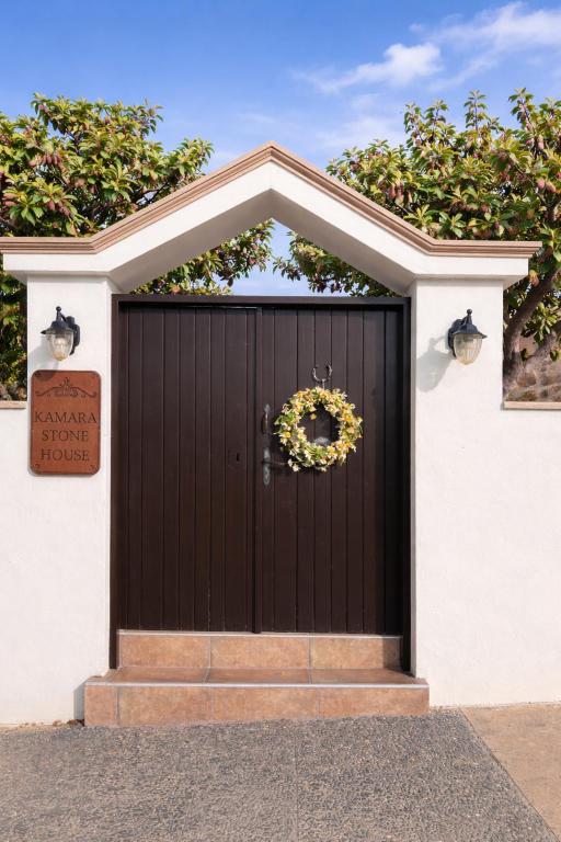 a black garage door with a wreath on it at Kamara Stone House in Kissamos