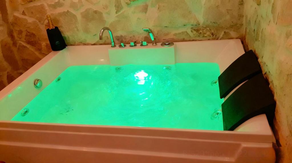a bathroom with a bath tub with blue water at Apulia lux in Taranto