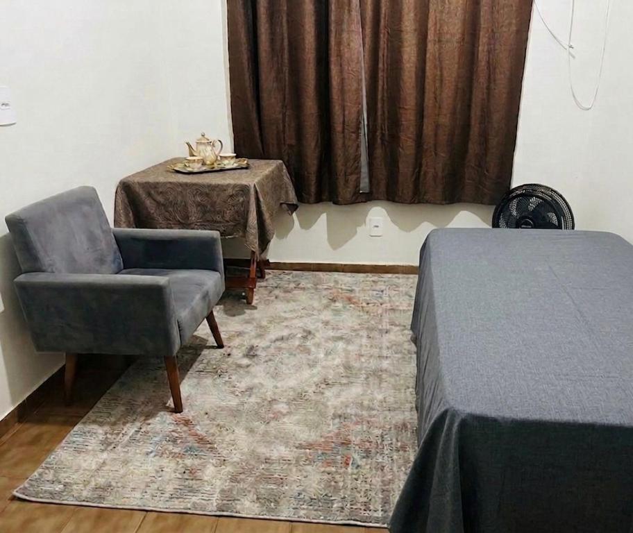 a room with a table and a chair and a table and a tableablish at Quarto Individual - Centro Rio Verde in Rio Verde