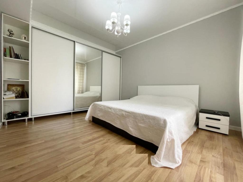 a white bedroom with a bed and a mirror at Buicani Confort Stay in Chişinău
