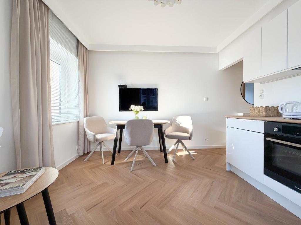 a kitchen and dining room with a table and chairs at Jaśminowy Apartament in Sławno