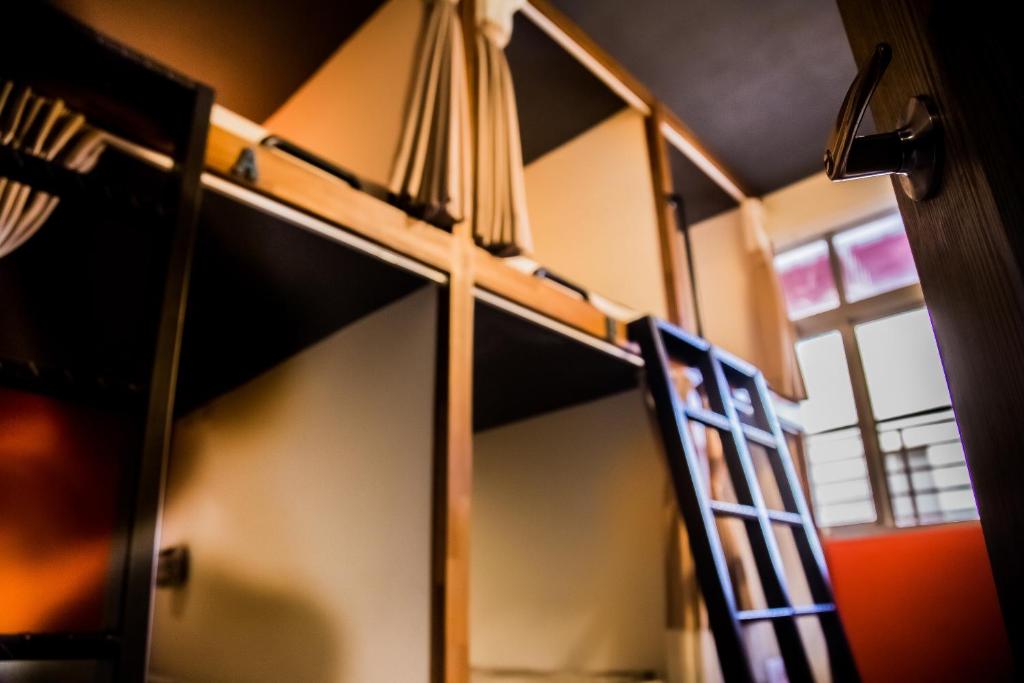 a bunk bed in a room with a ladder at Knock Knock Hostel in Kaohsiung