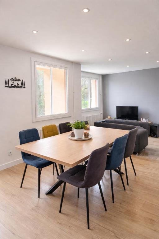 a dining room with a wooden table and chairs at L'entracte in Clairvaux-les-Lacs