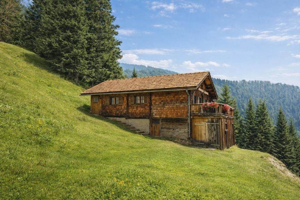 an old wooden building on a hill in a field at Turner-Hütte in Heiligenblut