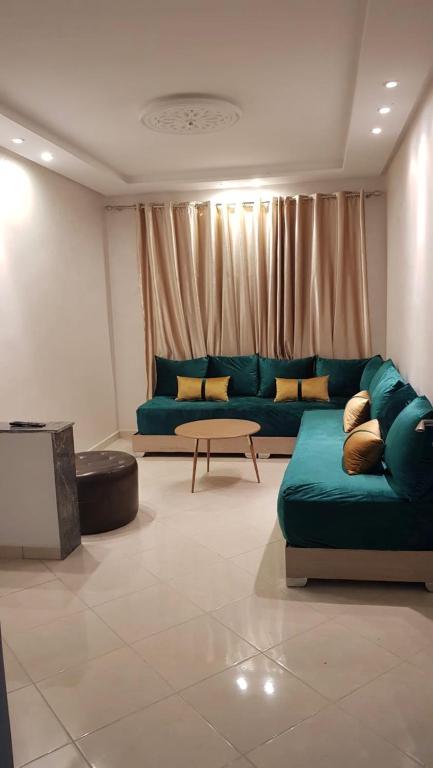 a living room with a green couch and a table at Apparemment BAHRA in Taza