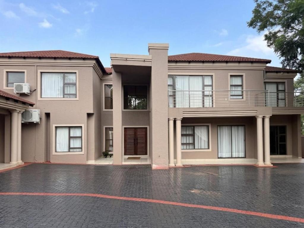 ein großes Haus mit einem Parkplatz davor in der Unterkunft Liquid Blue Guesthouse in Louis Trichardt