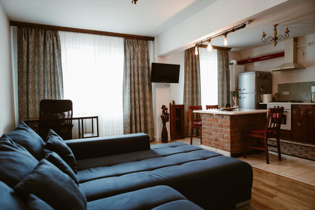 ein Wohnzimmer mit einer blauen Couch und eine Küche in der Unterkunft COM Home Tarnaveni - Free Parking - 24h Self check-in in Tîrnăveni