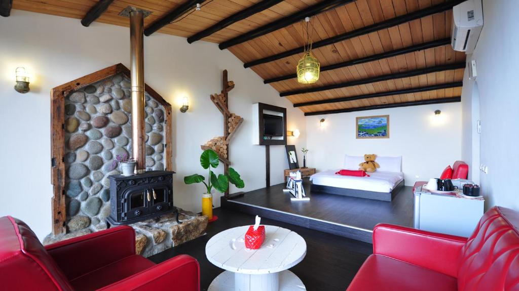 a living room with red chairs and a fireplace at Sunny Room in Jiufen