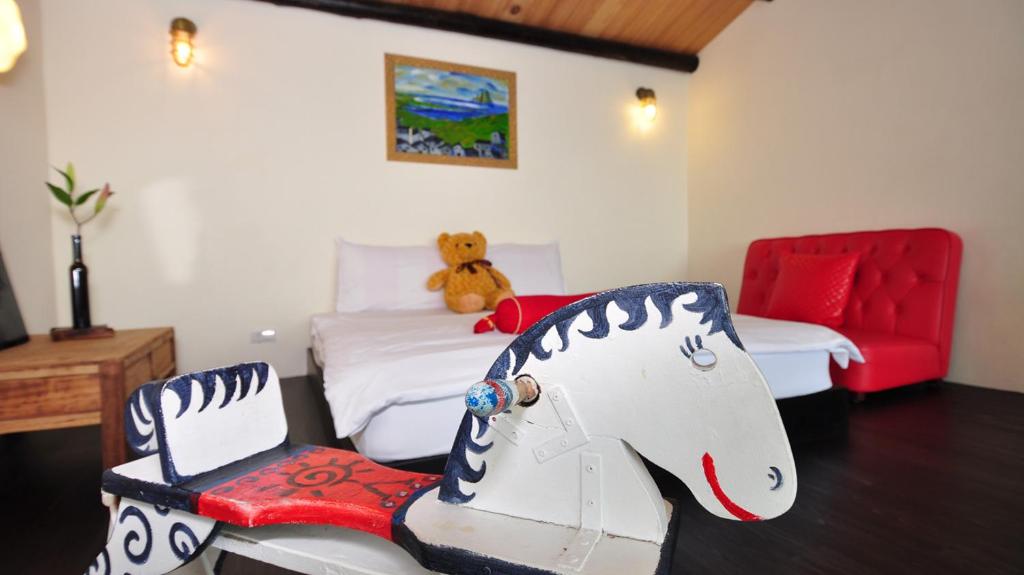 a bedroom with two beds and a teddy bear sitting on a chair at Sunny Room in Jiufen