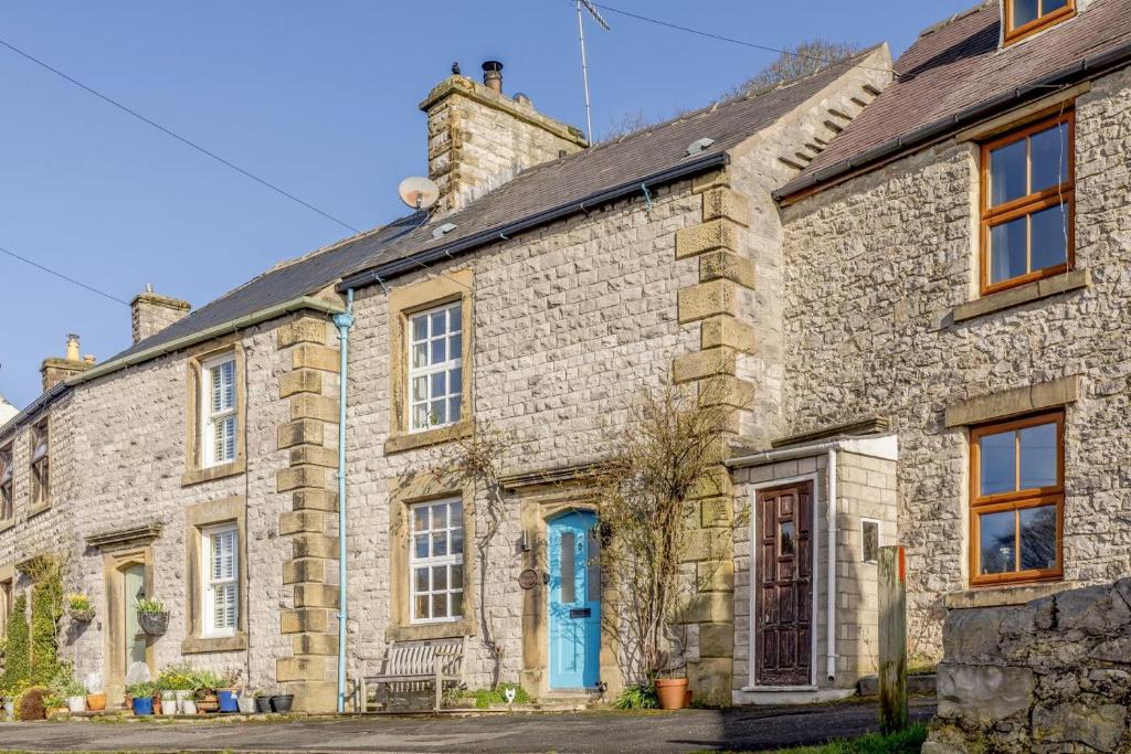 an old stone house with a blue door at 3 Bed in Tideswell oc-w39004 in Tideswell