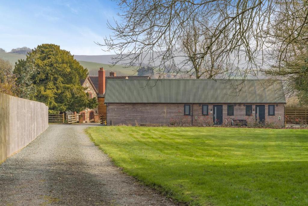 a brick house with a green lawn in front of it at 1 Bed in Minsterley oc-s38642 in Minsterley