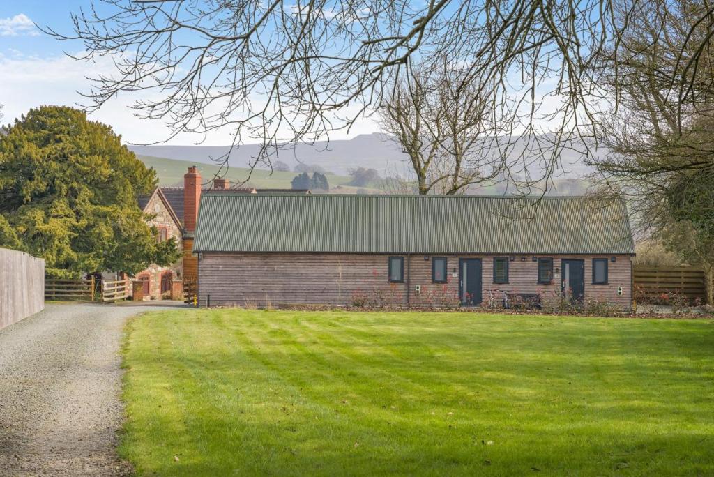 a brick house with a green roof on a grass field at 1 Bed in Minsterley oc-s38641 in Minsterley