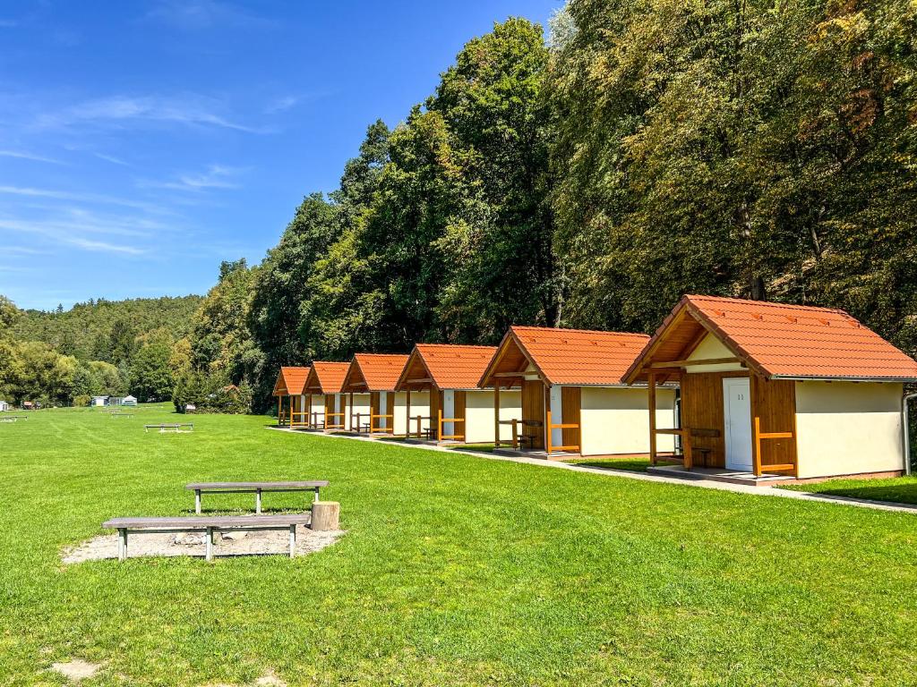 a row of buildings with a bench in a field at Kemp Koruna in Zlatá Koruna