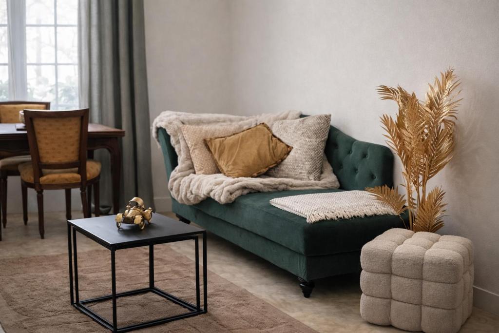 a living room with a green couch and a table at Gîte de Linéa Centre de Loches in Loches